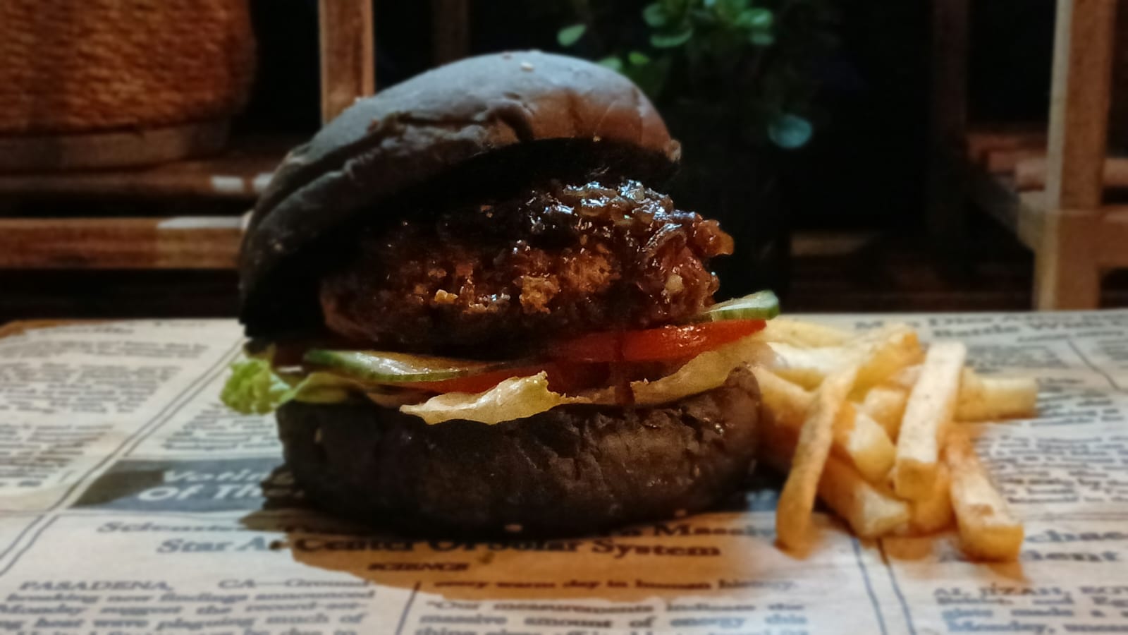 Signature burger on a black bun, served with chips