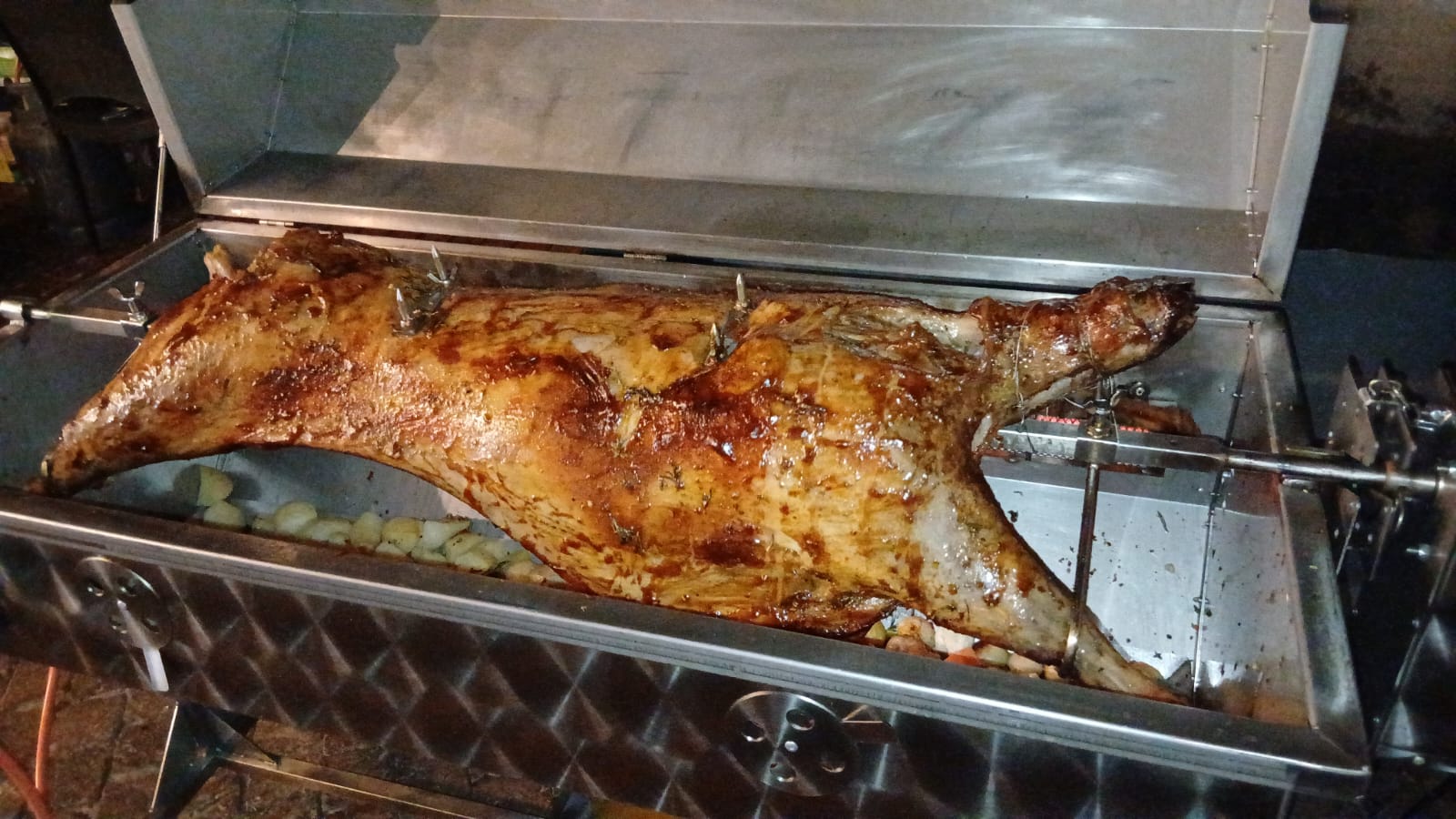 A whole lamb turning on the spit, glazed and golden