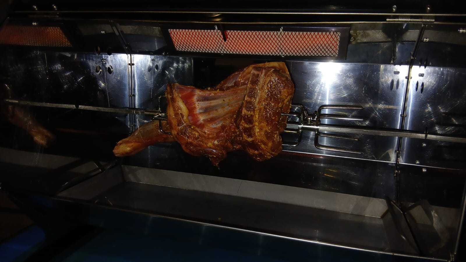 Marinated lamb turning on the spit rotisserie