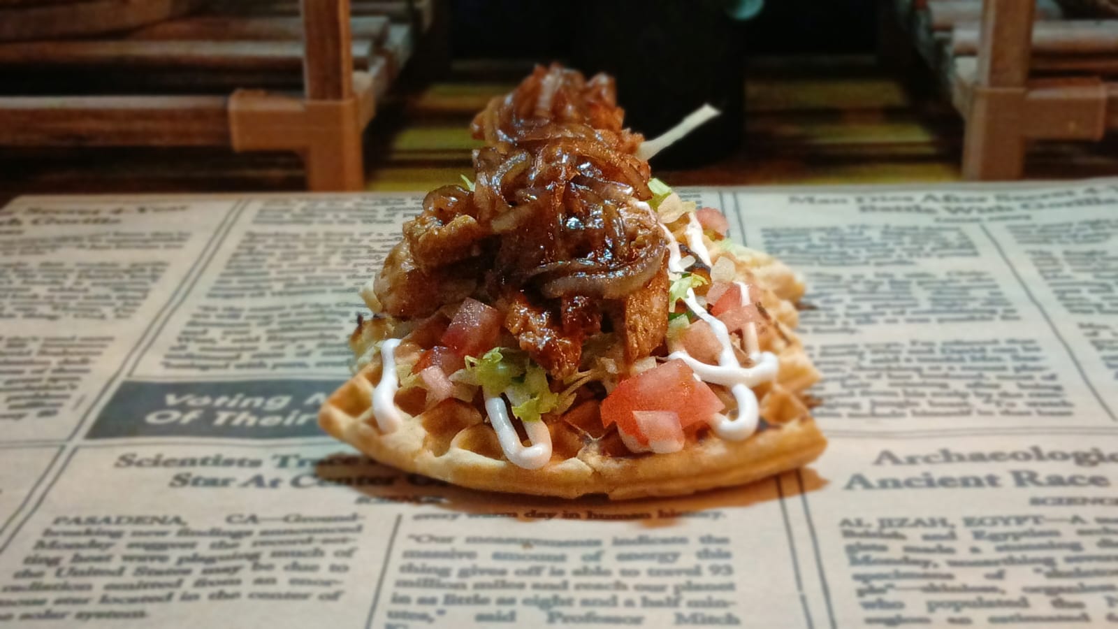 A waffle meal: grilled steak on a crispy waffle with salsa, lettuce and sauce